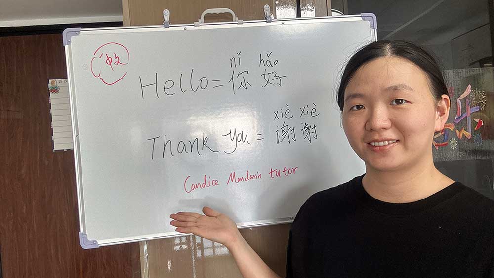 Candice presenting her Mandarin course beside a whiteboard with her name and basic lesson information.